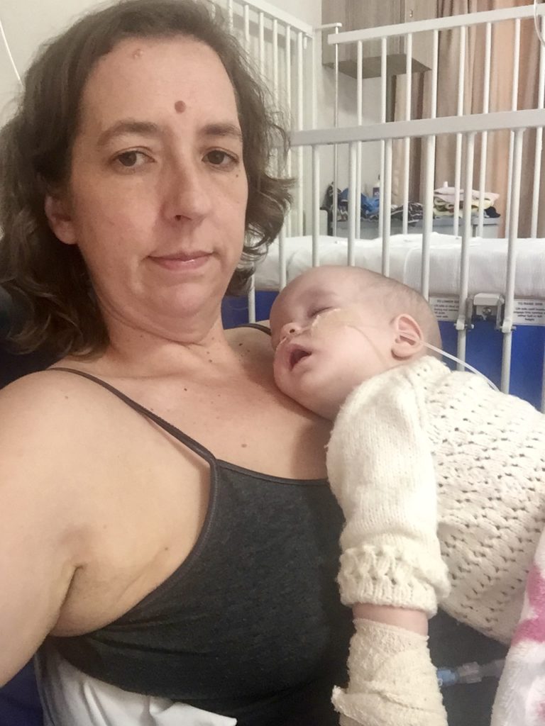 Ayla asleep on mom in hospital.