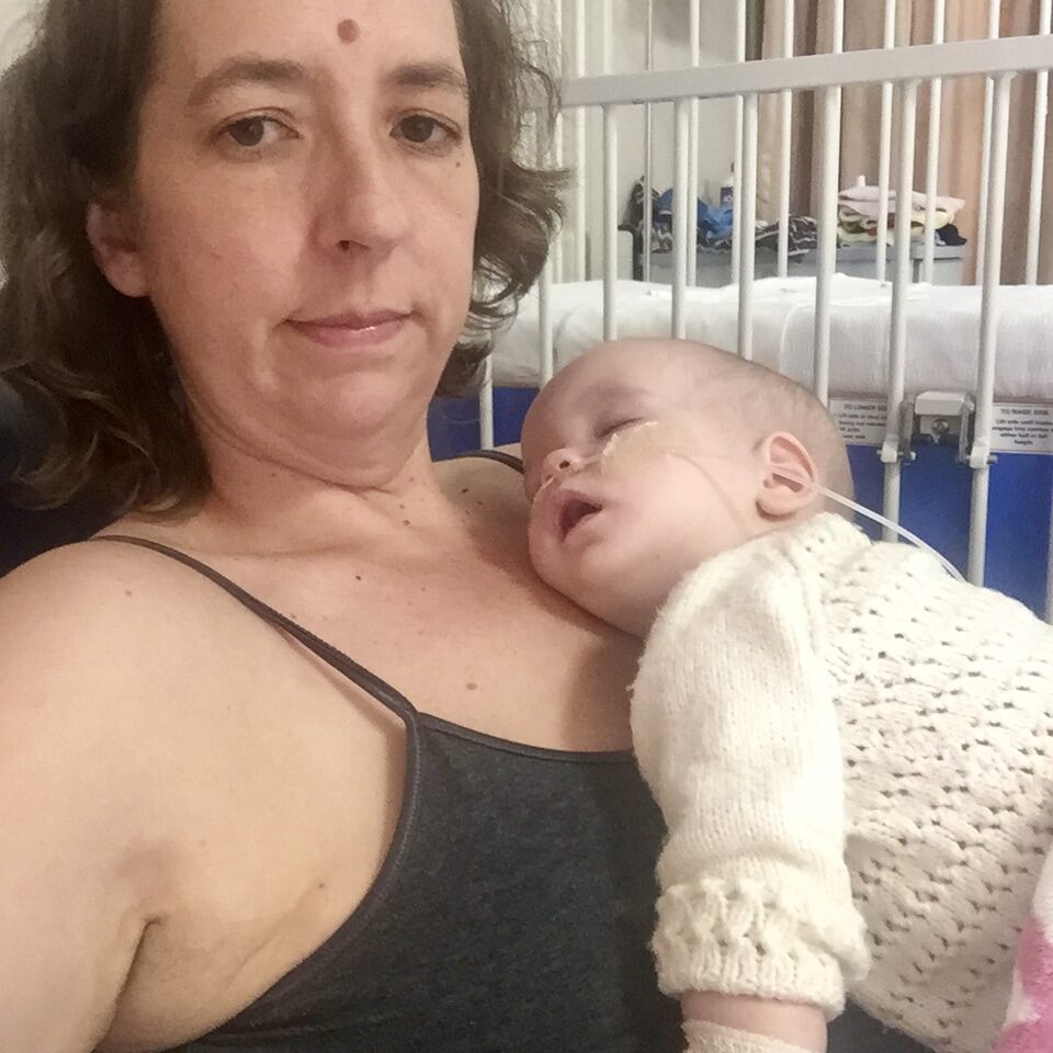 Ayla asleep on mom in hospital.